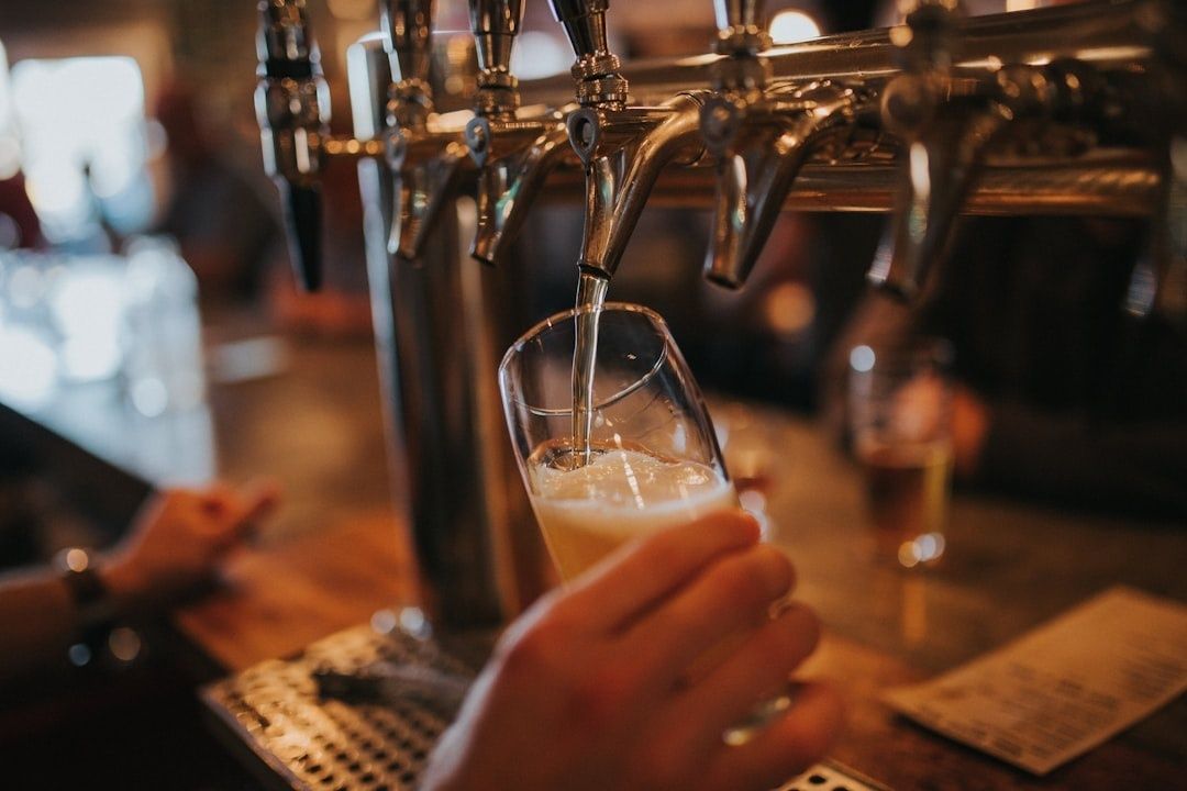 Öl hälls från en tappkran i ett glas med skumkrona
