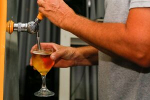 Öl tappas från en kran till ett glas med skum